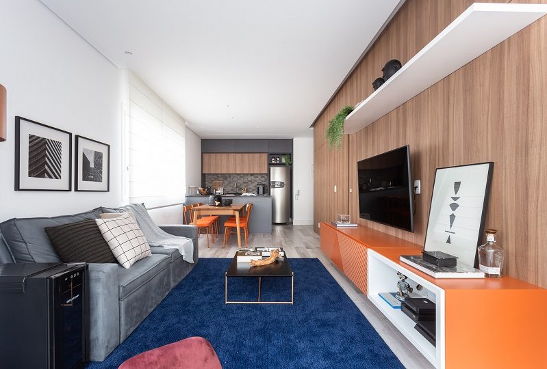 sala de estar com tapete azul e rack laranja