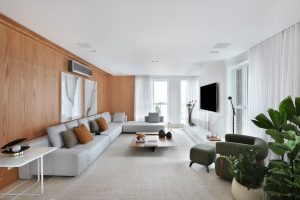 Sala de estar e TV com painel de madeira e um grande sofá